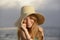 Blond woman with sunhat on the beach