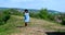 Blond woman walking in the grass wearing blue dress romantic alone boots