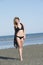 Blond woman wear black bikini walking at the beach
