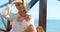 Blond Woman Wearing White Sweater on Ocean Pier