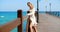 Blond Woman in White Cover Up Standing on Pier