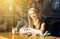 Blond young woman with cocktail or latte at table in cafe