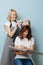 Blonde barber lady selecting hair tone for a client over blue background