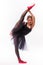 Blonde beautiful girl in black tutu dress doing gymnastic split.