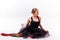 Blonde beautiful girl in black tutu dress doing gymnastic split.