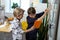 Blonde boy carrying orange tablet while his friend writing on the desk