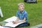 blonde boy learning to draw objects outdoors on the plein air