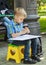 blonde boy learning to draw objects outdoors on plein air