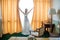 The blonde bride in a boudoir dress opens the curtains in the hotel room and looks out the window while preparing for the wedding
