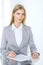 Blonde business woman examining contract while sitting at the glass desk in office background . Lawyer or secretary