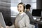 Blonde business woman talking by headset while sitting in modern call center office. Telemarketing and customer service