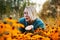 Blonde caucasian female with bob haircut blows kiss. Autumn woman portrait with bright orange flowers