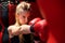 Blonde Caucasian fighter girl punching actively. Practicing in red Boxing Gloves