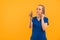 a blonde caucasian nurse in blue using a Stethoscope - closeup orange background