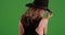 Blonde Caucasian woman modeling black hat on green screen