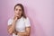 Blonde caucasian woman standing over pink background looking sleepy and tired, exhausted for fatigue and hangover, lazy eyes in