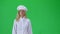 Blonde cook chef in white uniform and hat going against a green screen. Slow motion