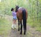 Blonde cowgirl woman posing with horse