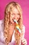 Blonde curly girl biting lollipop