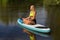Blonde dutch woman meditates on SUP in water