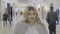 Blonde famous female at the mall playing with her hair and posing for her social media account before shopping for new outfit -