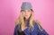 Blonde fashion model on pink background. Woman mysterious face wear hat. Confident and fashionable. Modern style. Girl