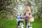 Blonde female with city bicycle with baby in bicycle chair