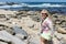 Blonde female explores the rugged, rocky beach of La Jolla California