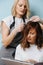 Blonde female hairdresser selecting hair tone for a client over blue background