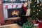 Blonde Female in Holiday Scene Holding Gifts Next to Tree