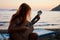 Blonde female playing acoustic guitar on the beach