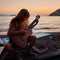 Blonde female playing acoustic guitar on the beach