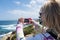 Blonde female takes a photo with smart phone of the rugged, rocky beach of La Jolla California