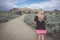 A blonde female walks on a path toward more abandoned buildings in the ghost town of Bodie California