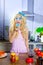 Blonde funny girl on kitchen eating blue dona