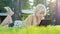 Blonde girl 6 years playing on the tablet, emotionally reacts. Lying on the lawn in the backyard of the house. Side view