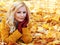 Blonde girl in Autumn Park with Maple leaves. Fashion Beautiful