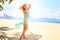 blonde girl in azure looks forward wind shakes hair on beach