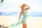 blonde girl in azure looks forward wind shakes hair on beach