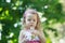 Blonde girl blowing on white Taraxacum officinale