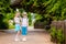 Blonde girl and boy in the hat and big glasses under the huge green tree