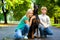 Blonde girl and boy hugs beloved dog or doberman