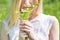 Blonde girl in field picking daisy in hand