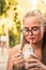 Blonde girl with glasses enjoys her milkshake. Drinking milkshake with the straw