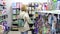 A blonde girl with a grocery basket in her hands walks around the store. A young girl walks around the supermarket