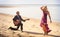 blonde girl and guitarist on beach at low tide