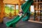 Blonde girl in the hat in the wooden house on the children playground