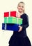 Blonde girl holding in hands lots of boxes with gifts on isolated background