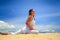 blonde girl in lace in yoga asana left leg stretch on beach