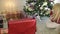 Blonde girl with long hair playing with Christmas gifts near a Christmas tree.